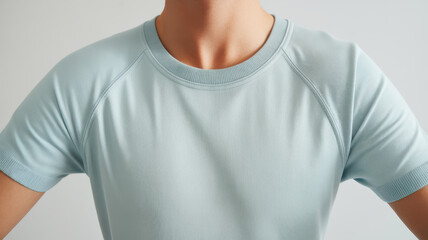 Close-up of an athletic male model in a light blue t-shirt, showcasing a modern and stylish design suitable for active lifestyles.