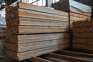 Stacked wooden planks close-up at lumber warehouse. Wood industry concept