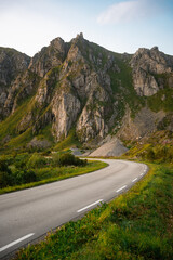 Naklejka premium Winding road that meanders gracefully through a serene, breathtaking mountain landscape