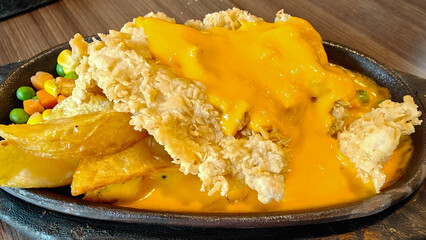 Crispy Chicken Steak with french fries and vegetables on black wooden plate
