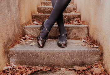 Woman's legs in tights and retro style heel shoes. Sepia tones, vintage mood - old 1920s fashion.