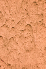 Vertical close-up photo of rough plaster.