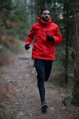 Trail running man runner going up in mountain fores