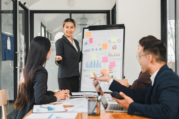 businesswoman presents data to colleagues in modern office setting, showcasing charts and graphs. team engages actively, discussing strategies and insights