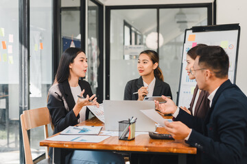 Efficient business meeting with professionals discussing strategies and ideas. team collaborates around table with documents and laptop, showcasing teamwork and communication