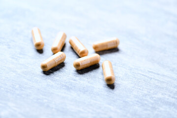 Korean Ginseng capsules. Concept for a healthy dietary supplementation. Wooden background. Soft focus. Close up.