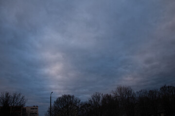 A dense, overcast sky at early morning with dark clouds covering the scene.
