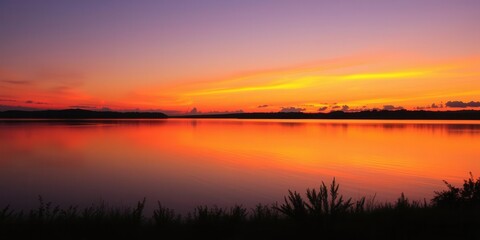 Obraz premium Vibrant orange and purple sunset over a calm lake, orange, peaceful, dusk