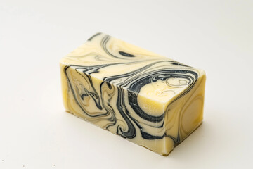 A handcrafted, marbled soap bar with swirling patterns, positioned at an angle on a clean white backdrop, highlighting its texture.