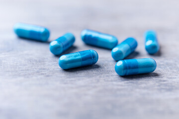 Amino acids capsules on wooden background. Soft focus. Close up. 