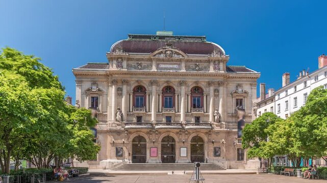 Timelapse hyperlapse of Theatre des Celestins in Lyon, France. A historic theatre on Place des Celestins with trees, benches and people relaxing under blue sky. Classic architecture and cultural charm