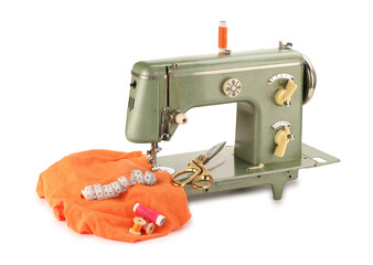 Sewing machine with orange fabric, measuring tape, scissors and spools of threads isolated on white