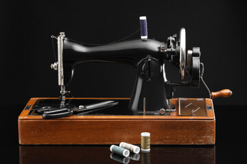 Vintage professional sewing machine on black background