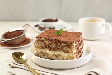 Delicious tiramisu with mint on light table, closeup