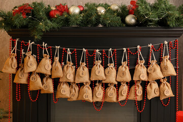Christmas advent calendar with gifts and decor hanging on fireplace indoors