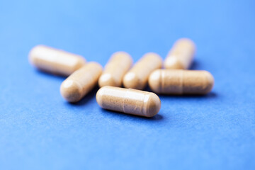 Korean Ginseng capsules. Concept for a healthy dietary supplementation. Bright paper background. Close up.