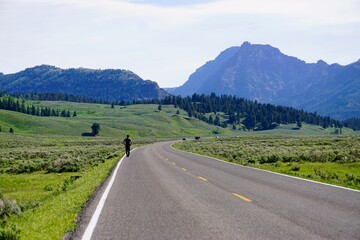 Fototapeta premium Man on a journey walks alone on a long and winding road
