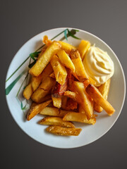 Close Up of a decorated dinner plate with nicely browned nutritious Dutch fries and mayonnaise