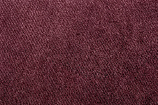 Close-up of rich burgundy velour texture, showcasing a smooth and soft fabric surface.