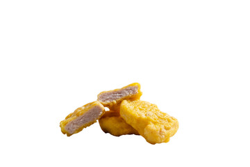Chicken nuggets are stacked on top of each other, one of them is cut in half.