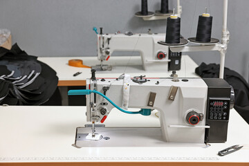 Sewing machines with spools of thread in professional workshop
