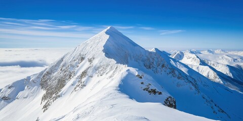 Naklejka premium A mountain range covered in snow with a blue sky in the background. The snow is piled up on the mountain tops, creating a beautiful and serene landscape. Concept of peace and tranquility