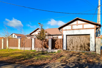 Beautiful half-timbered country house with a garage and a brown wooden fence.