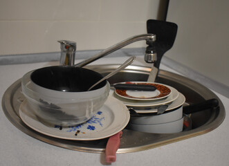 Dirty kitchenware, plates and mugs. Pile of unwashed, dirty dishes in the sink. Mess in the...