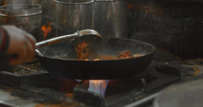 Man cooking street food Biryani on a busy street. Slow motion Biryani is a mixed rice dish, mainly popular in South Asia. It is made with rice, some type of meat chicken, goat, lamb, beef, prawn, or