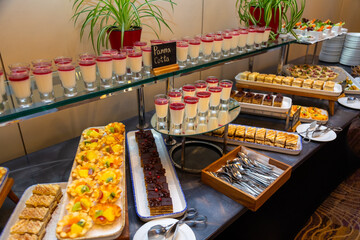 Buffet display with panna cotta, fruit tarts, and chocolate desserts in focus