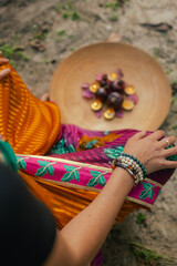 Close-up Indian Woman in traditional saree hand lighting Diya lamp during Diwali festival. Happy greeting photo. Part of a series