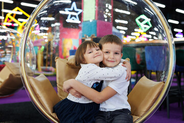 Happy and cheerful children, a boy and a girl, in a modern playroom.