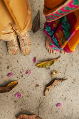 Close-up of Newlyweds couple feet at Indian wedding ceremony outdoors. Happy Diwali greeting photo. Part of a series