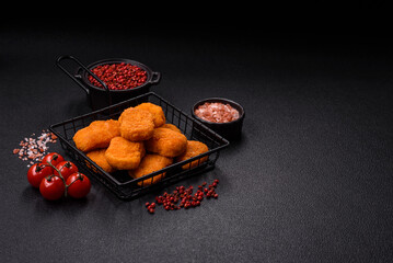 Delicious fresh crispy chicken nuggets on a dark concrete background