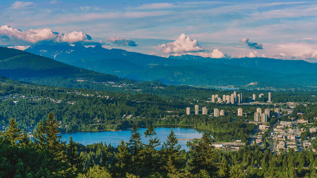 Aerial view of Fraser Valley, BC, with Burrard Inlet at Port Moody and forested mountain backdrop.