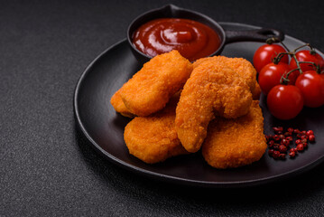 Delicious fresh crispy chicken nuggets on a dark concrete background