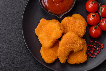 Delicious fresh crispy chicken nuggets on a dark concrete background