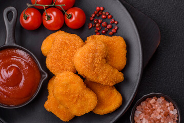 Delicious fresh crispy chicken nuggets on a dark concrete background