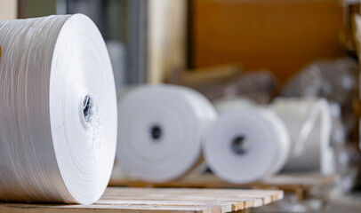 Production of plastic bags, closeup roll on extruder of polyethylene, banner