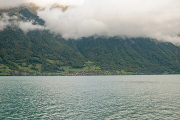 The town of Oberried, mountains, forests and Lake Brienz below thick clouds, Switzerland