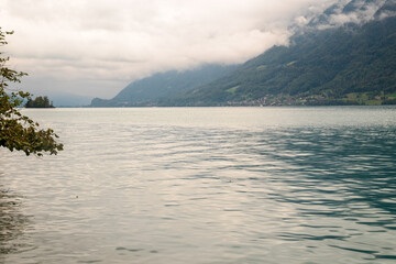 The water of Lake Brienz under low clouds and the north shore with Oberried and the mountains, Switzerland
