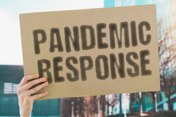 The phrase 'Pandemic Response' on a banner in a person's hand. Human holds a cardboard with an inscription. Health. Preparedness. Emergency. Prevention. Resilience. Recovery. Safety