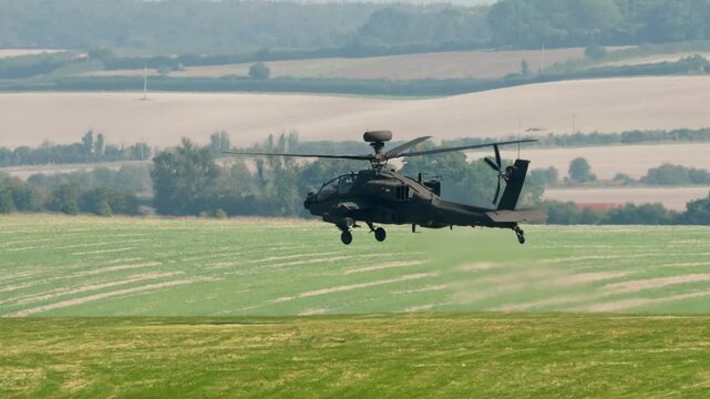 British army Boeing Apache Attack helicopter gunship AH64E AH-64E ArmyAirCorp AAC AH2 in low level flight performing low-level hover manouevres 