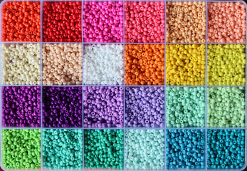 Colorful glass beads in a box. Beautiful tiny glass beads for embroidery. Beads in compartment box for crafting. 