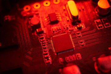 A visually striking macro shot featuring a detailed circuit board illuminated with vibrant red hues and tones