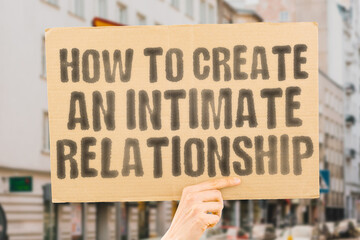 The phrase 'How to Create an Intimate Relationship' on a banner in a person's hand. Human holds a cardboard with an inscription. Love. Trust. Connection. Emotion. Understanding. Bond. Affection