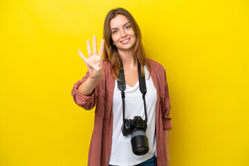 Young photographer caucasian woman isolated on yellow background happy and counting four with fingers