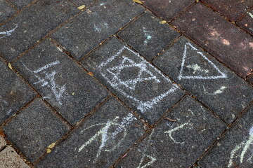 Children's chalk drawings on the sidewalk in the city.