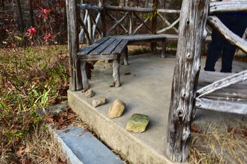 Rocks on step of wooden structure with bench in park