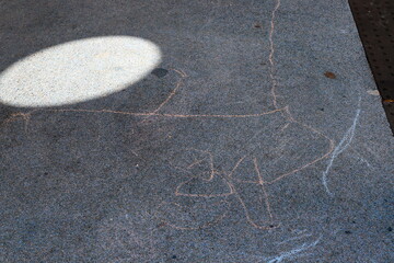 Children's chalk drawings on the sidewalk in the city.